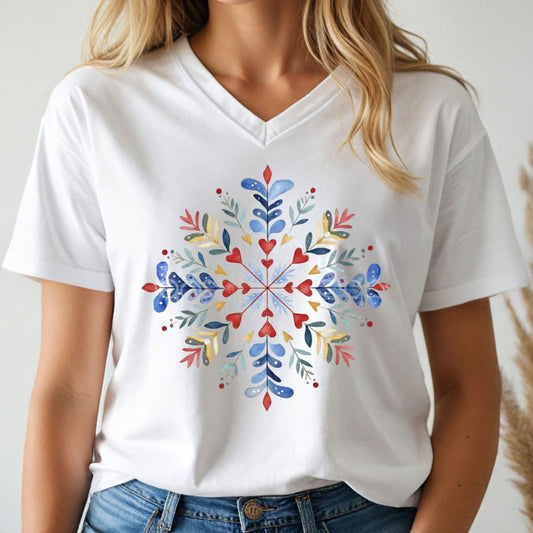 A woman wearing a white V-neck t-shirt with a colorful watercolor snowflake graphic on the front, paired with blue jeans.
