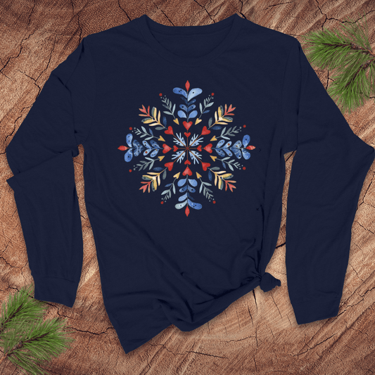 Navy long sleeve shirt with a colorful floral snowflake design on a wooden surface.