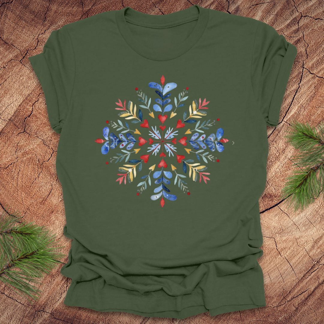 Military green t-shirt with a colorful snowflake and floral design on a wooden surface
