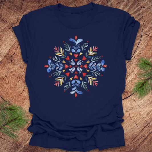 Navy blue t-shirt with a colorful snowflake and floral design on a wooden surface
