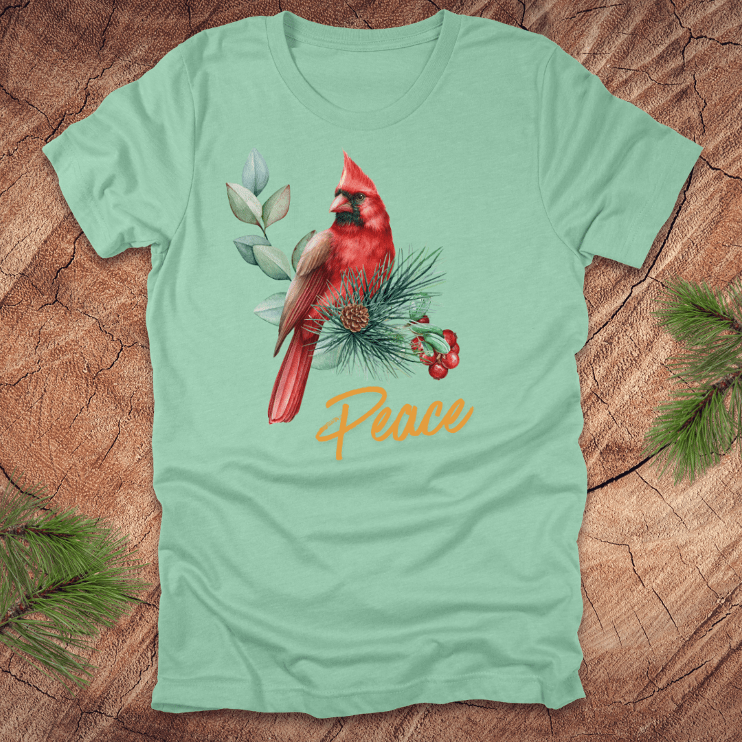 Light green t-shirt with a red cardinal and 'Peace' text on a wooden surface
