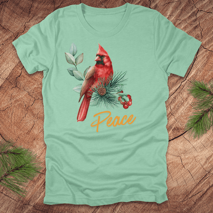 Light green t-shirt with a red cardinal and 'Peace' text on a wooden surface