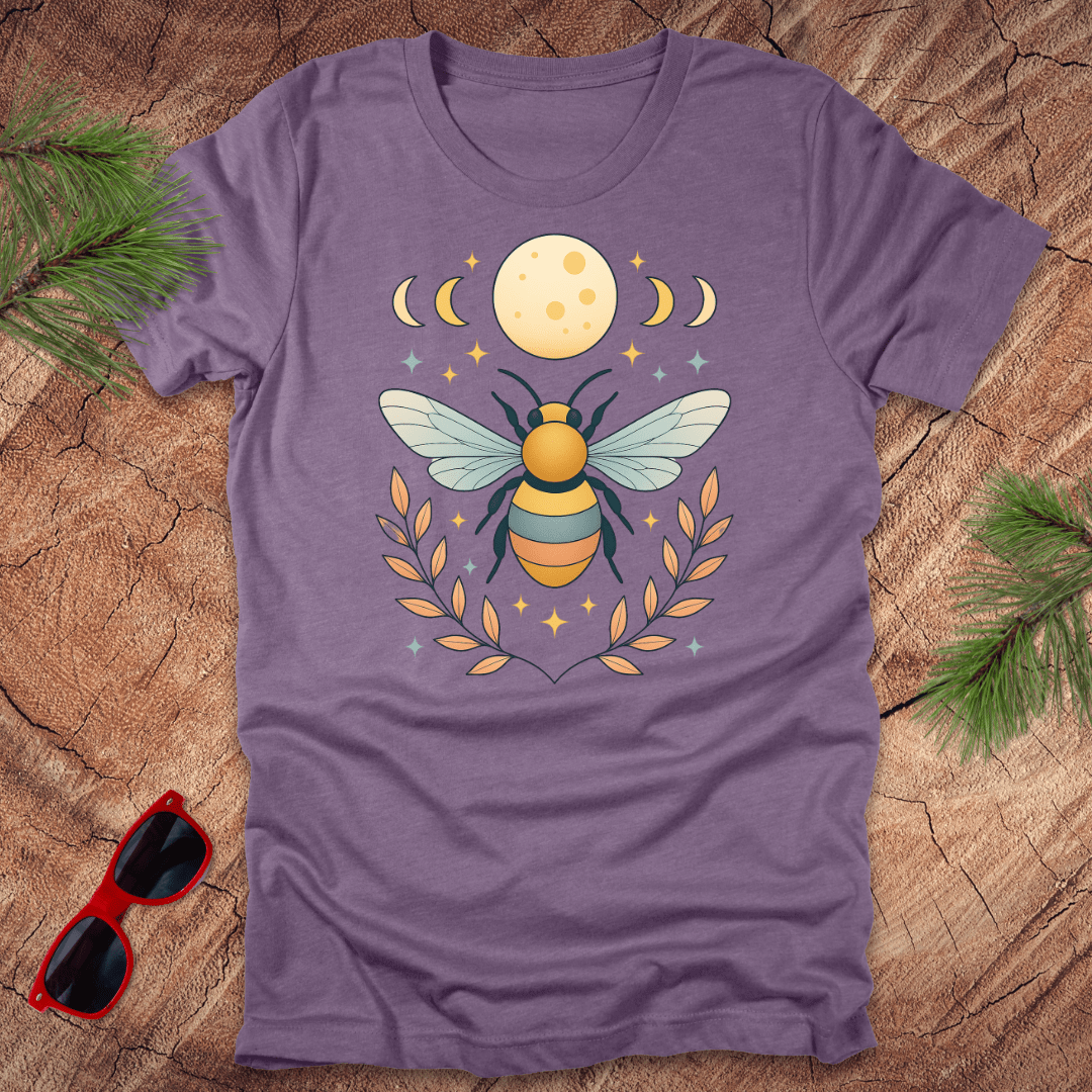 Purple tshirt with a bee and moon graphic on a wood background.