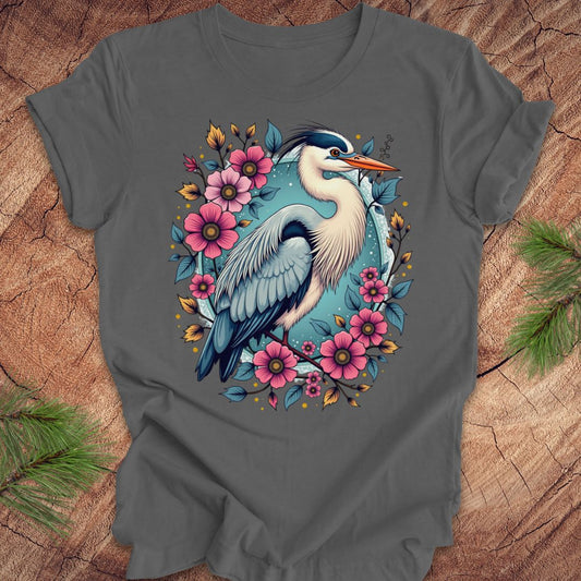 Gray t-shirt with a heron and floral design on a wood background.