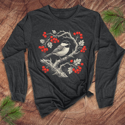 Dark gray long-sleeve tshirt with a chickadee and holly berry design on a wooden surface