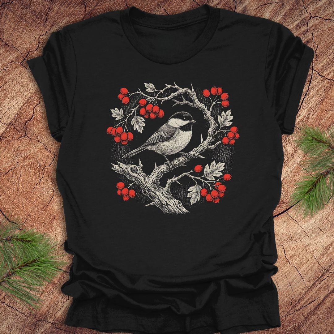 Black t-shirt with a chickadee and holly  berry design on a wooden surface