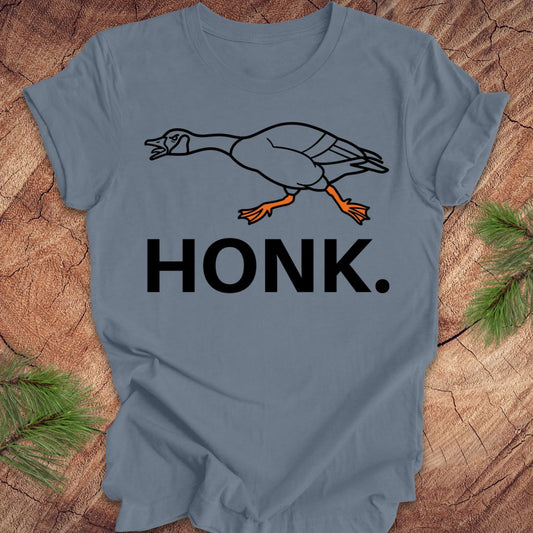 Steel blue t-shirt with a goose graphic and 'HONK.' text on a wooden surface.
