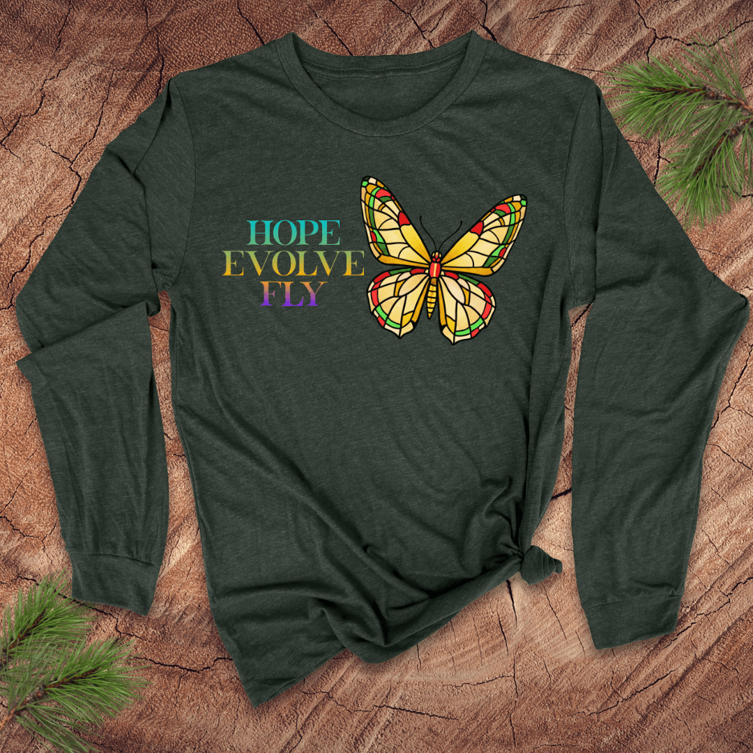 Green long-sleeve shirt with a butterfly graphic and 'Hope Evolve Fly' text on a wooden surface.