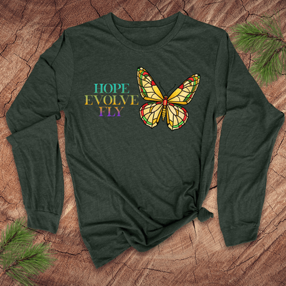 Green long-sleeve shirt with a butterfly graphic and 'Hope Evolve Fly' text on a wooden surface.