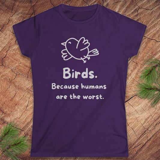 A purple short-sleeve crewneck t-shirt with a white graphic of a bird and the text 'Birds. Because humans are the worst.