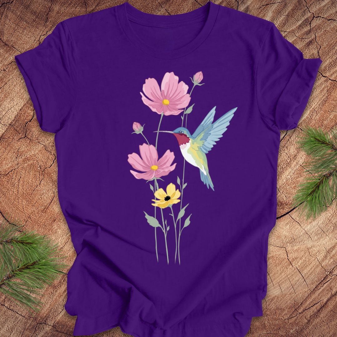 Purple t-shirt with a hummingbird and floral design on a wooden surface