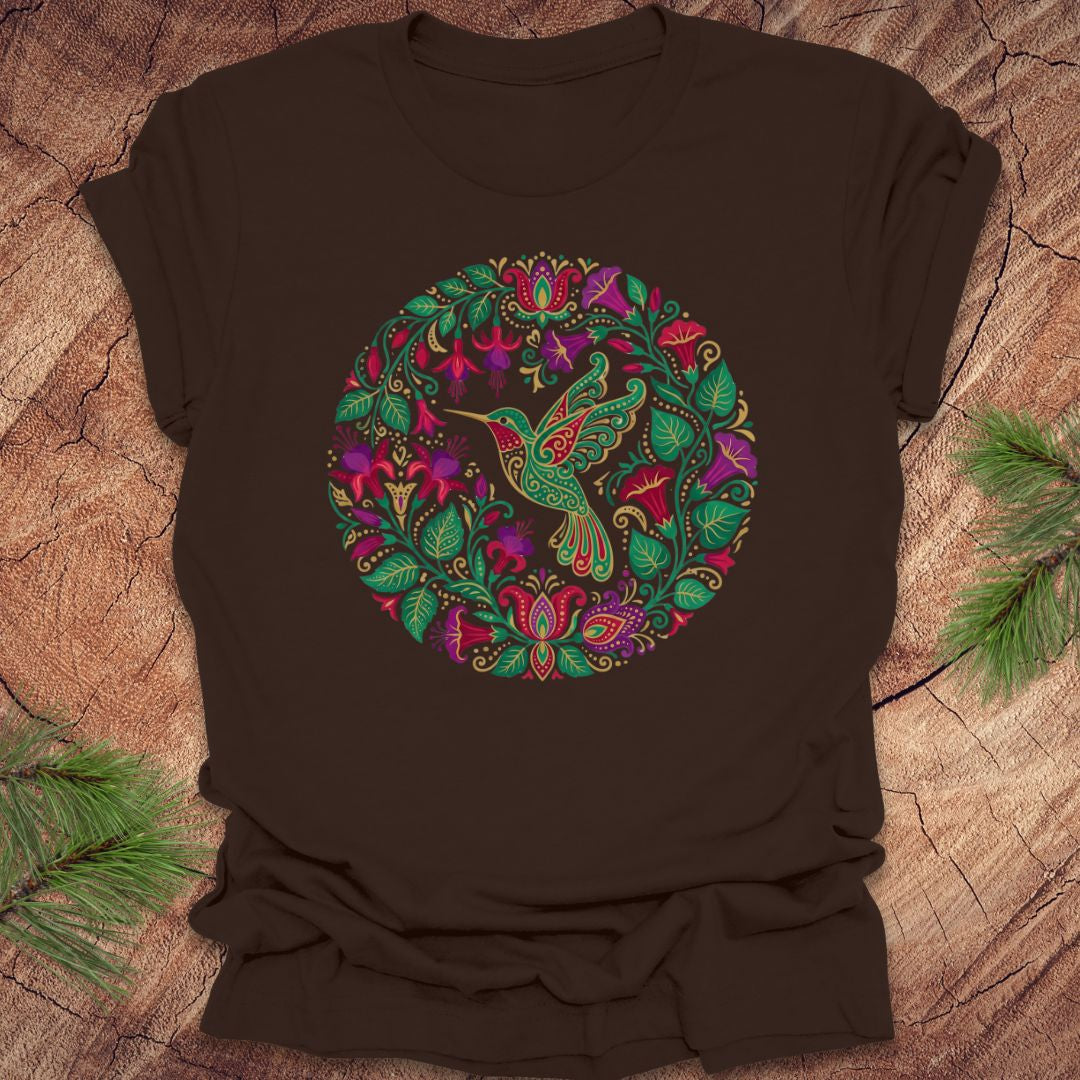 Brown t-shirt with a colorful bird and floral design on a wooden surface