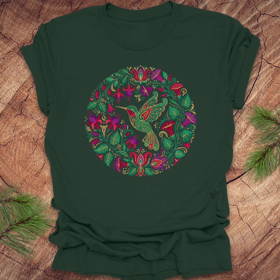 Green t-shirt with a colorful bird and floral design on a wooden surface