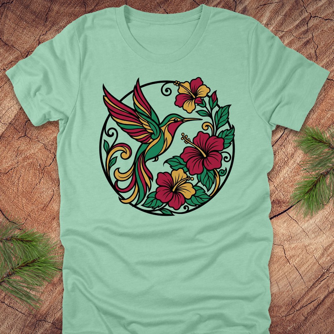 Light green t-shirt with a colorful hummingbird and floral design on a wooden surface.