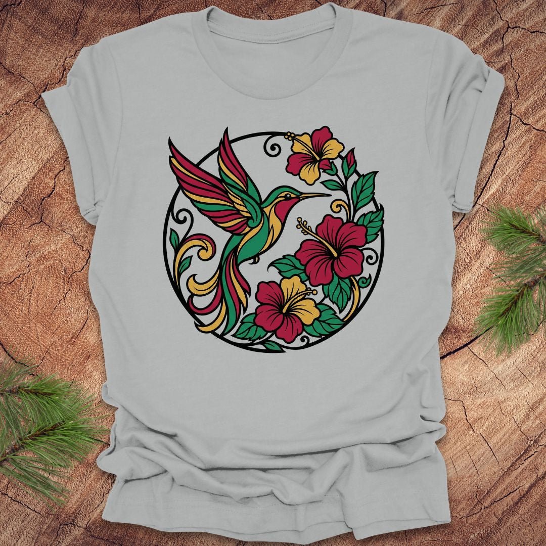 Gray t-shirt with a colorful hummingbird and floral design on a wooden surface.