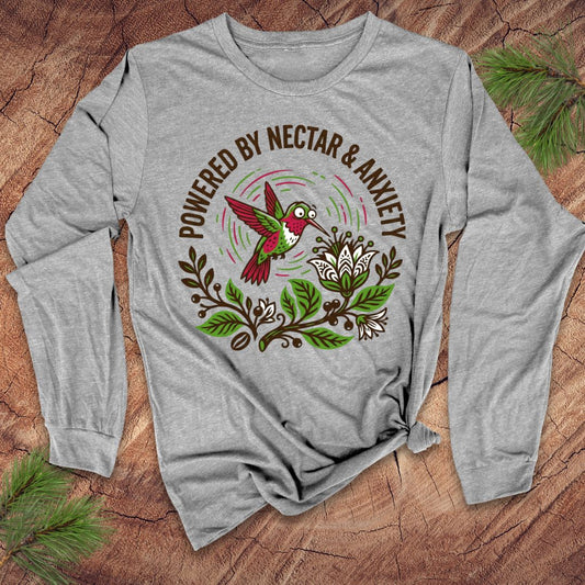 Gray long-sleeve shirt with a colorful hummingbird graphic and text on a wooden surface.