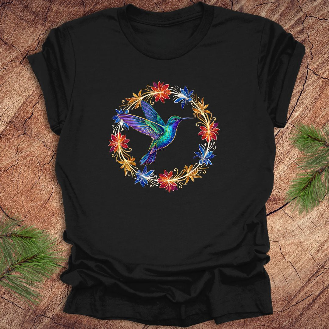 Black t-shirt with a colorful hummingbird and floral design on a wooden surface.