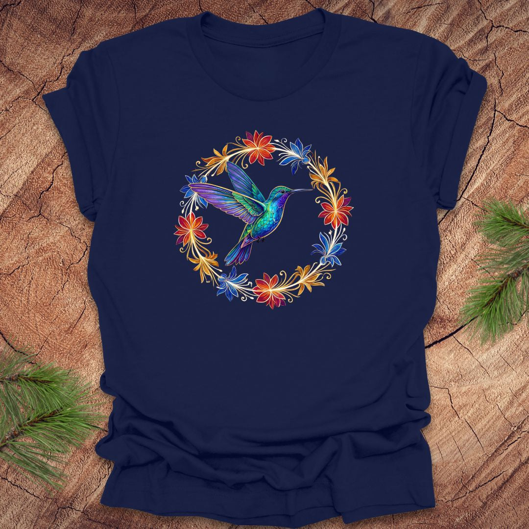 Navy blue t-shirt with a colorful hummingbird and floral design on a wooden surface.