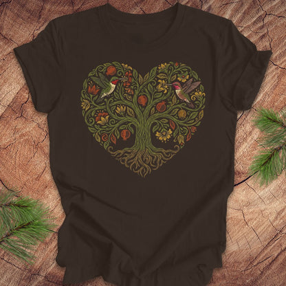 Brown t-shirt with a heart-shaped tree design featuring hummingbirds on a wooden surface.