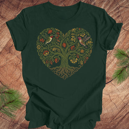 Green t-shirt with a heart-shaped tree design featuring hummingbirds on a wooden surface.