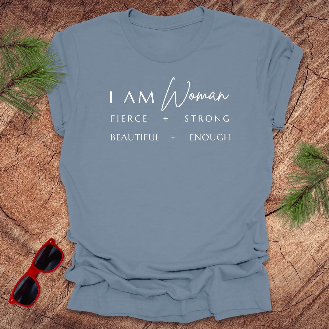 A steel blue unisex short-sleeve t-shirt with the text 'I AM Woman Fierce. Strong. Beautiful. Enough.' printed in white.