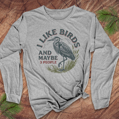 Gray long-sleeve t-shirt with a great blue heron and text on a wood background.