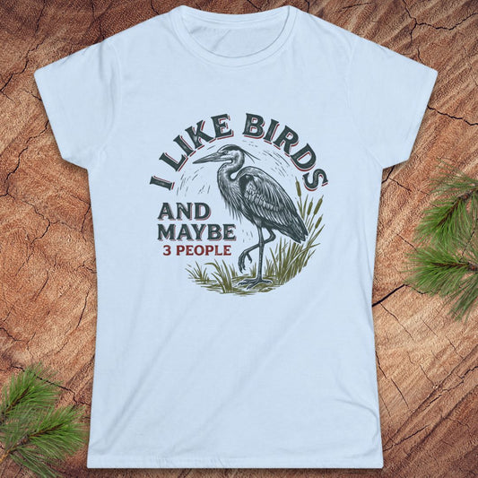 Blue t-shirt with a heron bird and text on a wood background.