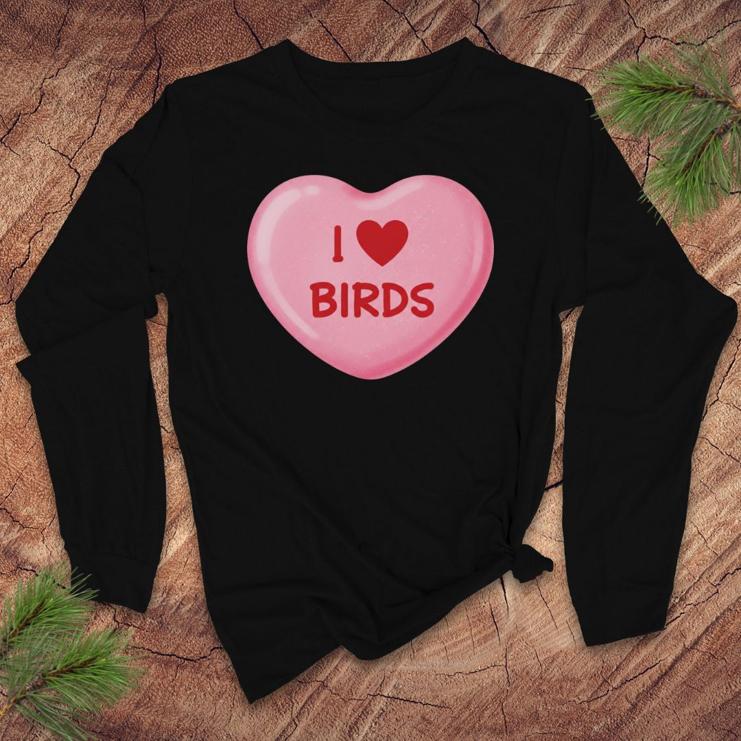 Black sweatshirt with a pink candy heart design and 'I ❤️ BIRDS' text on a wooden surface.