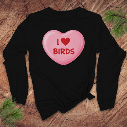 Black sweatshirt with a pink candy heart design and 'I ❤️ BIRDS' text on a wooden surface.