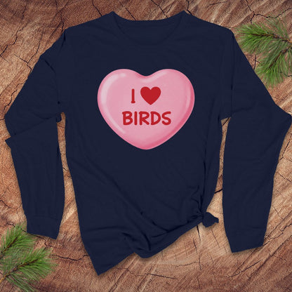 Navy blue long sleeve shirt with a pink heart-shaped candy design and 'I ❤️ BIRDS' text on a wooden surface.