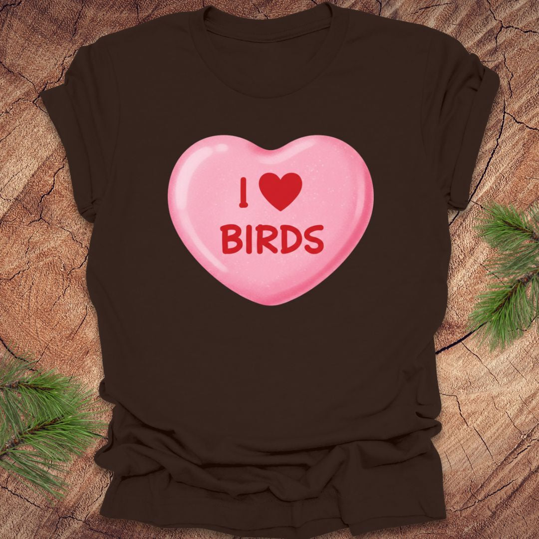 Brown t-shirt with a pink heart-shaped candy design on a wooden surface