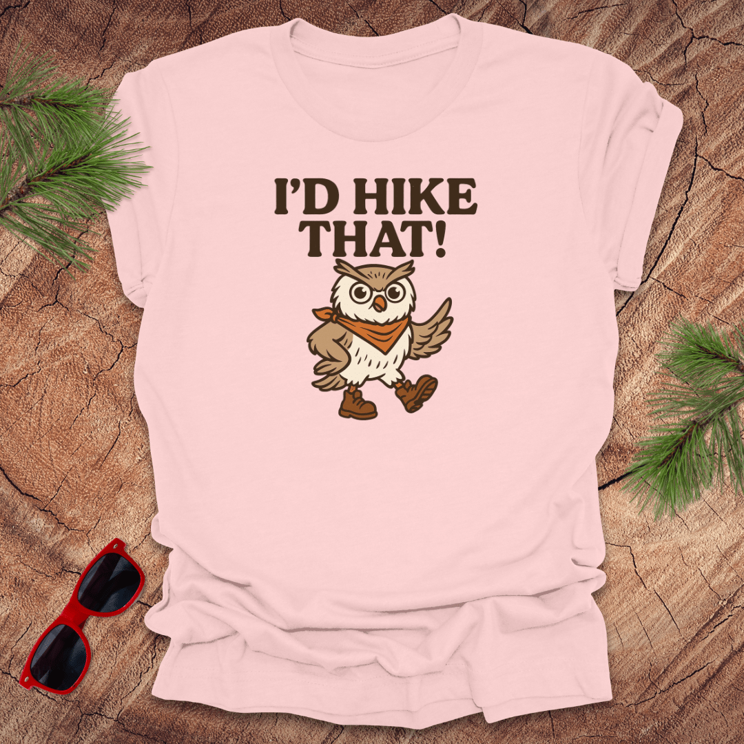A pink t-shirt with a graphic of an owl wearing a hat and the text 'I'D HIKE THAT!' printed above.