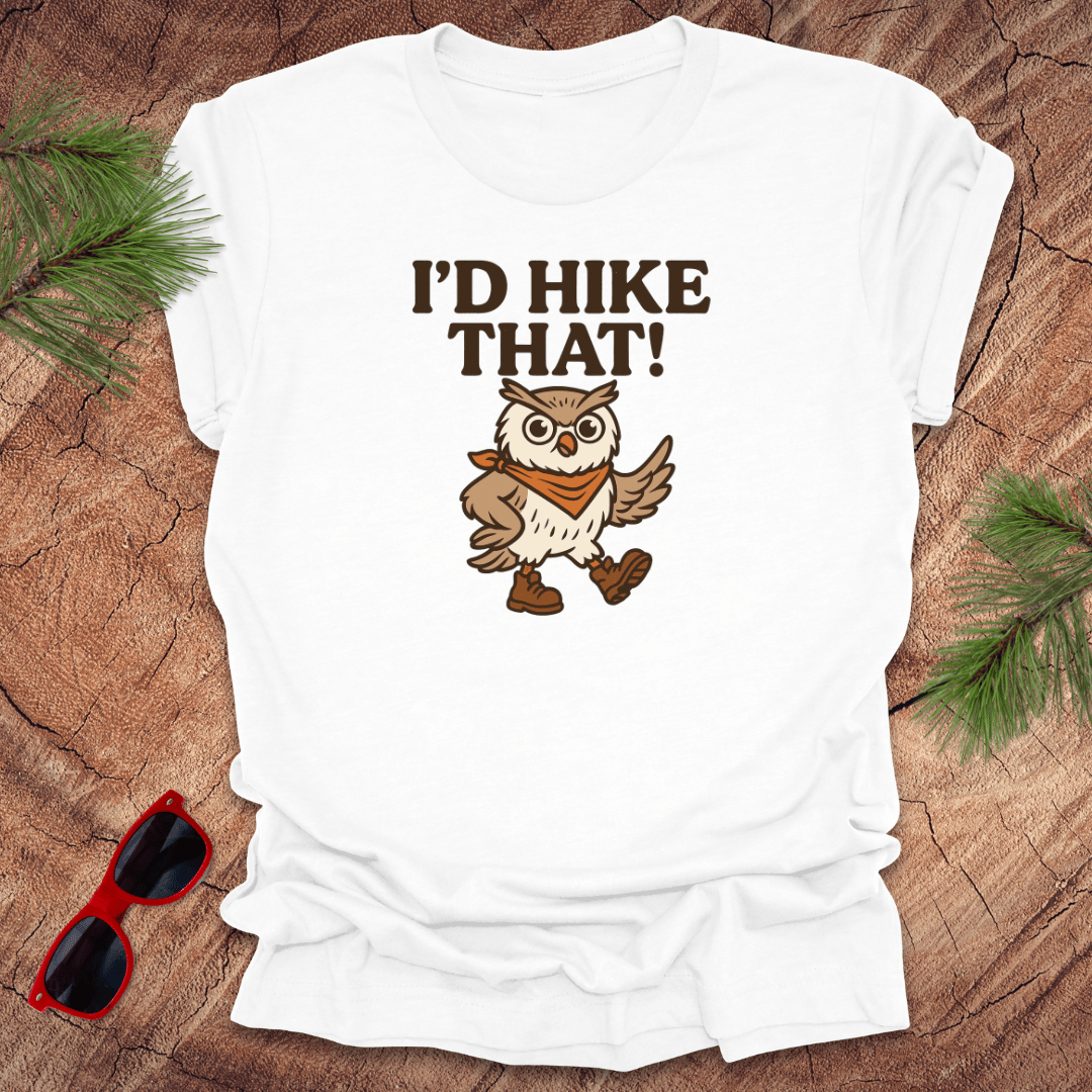 A white t-shirt with a graphic of an owl wearing a hat and the text 'I'D HIKE THAT!' printed above.