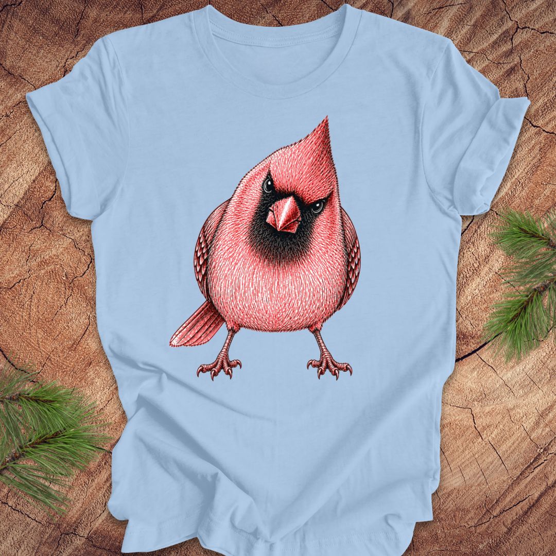 Light blue t-shirt with a red cardinal bird design on a wooden surface.
