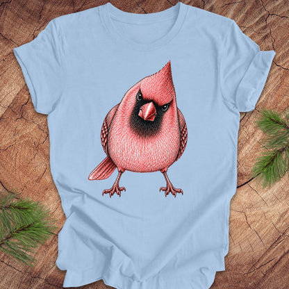 Light blue t-shirt with a red cardinal bird design on a wooden surface.