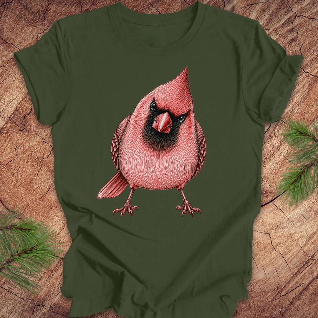 Green t-shirt with a red cardinal bird design on a wooden surface.