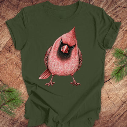 Green t-shirt with a red cardinal bird design on a wooden surface.