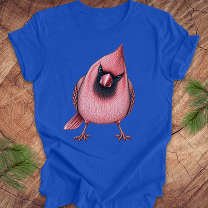 Blue t-shirt with a red cardinal bird design on a wooden surface.