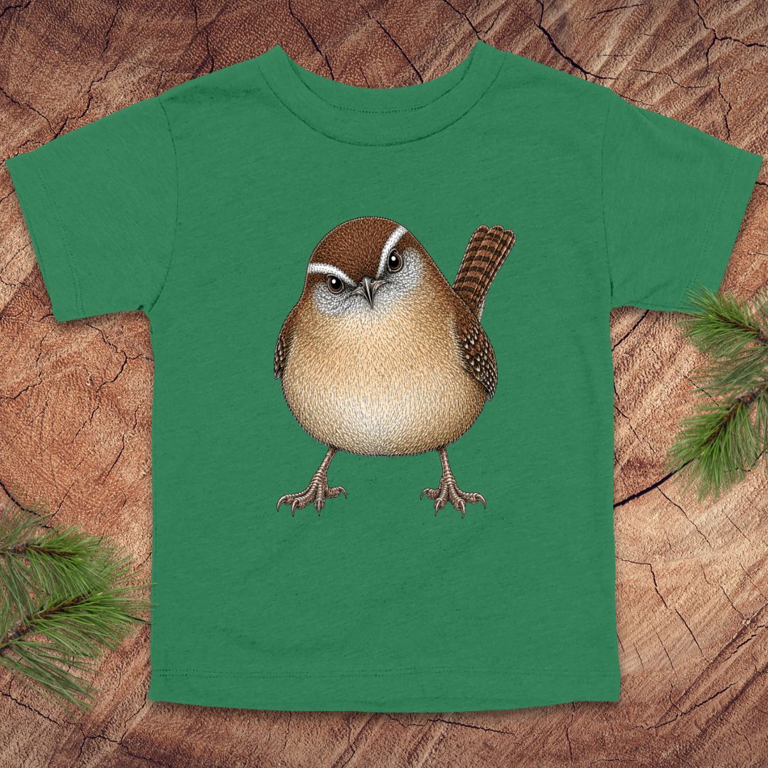 Green toddler t-shirt with a carolina wren design on a wooden surface