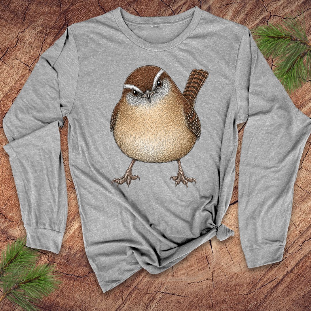 Gray long-sleeve t-shirt with a carolina wren design on a wood background.