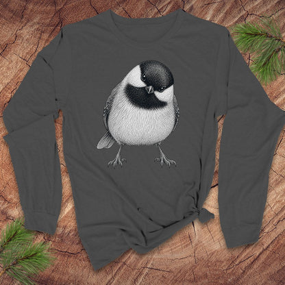 Dark gray long-sleeve shirt with a chickadee design on a wooden surface with pine branches.