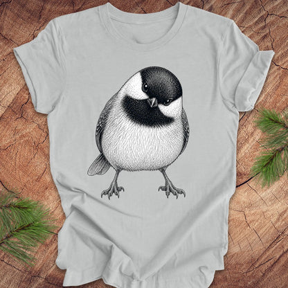 Grey t-shirt with a chickadee design on a wooden surface