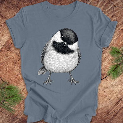 Blue t-shirt with a chickadee design on a wooden surface