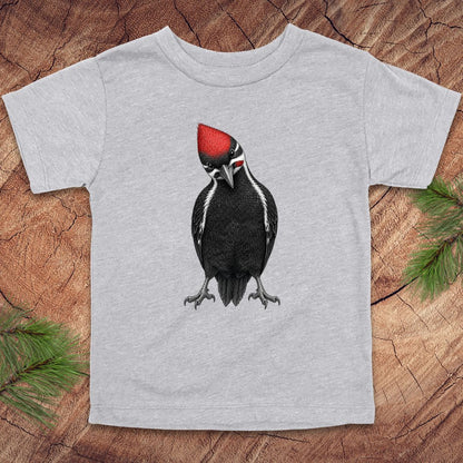 Gray toddler t-shirt with a woodpecker design on a wooden surface