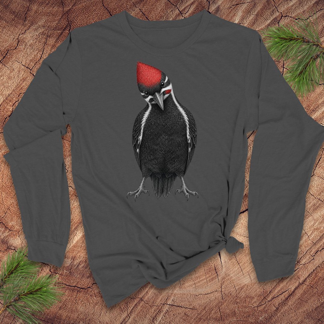 Dark gray long-sleeve shirt with a woodpecker design on a wooden surface with pine branches.