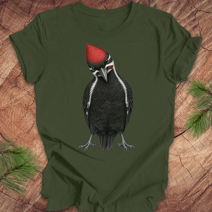 Green t-shirt with a woodpecker design on a wooden surface