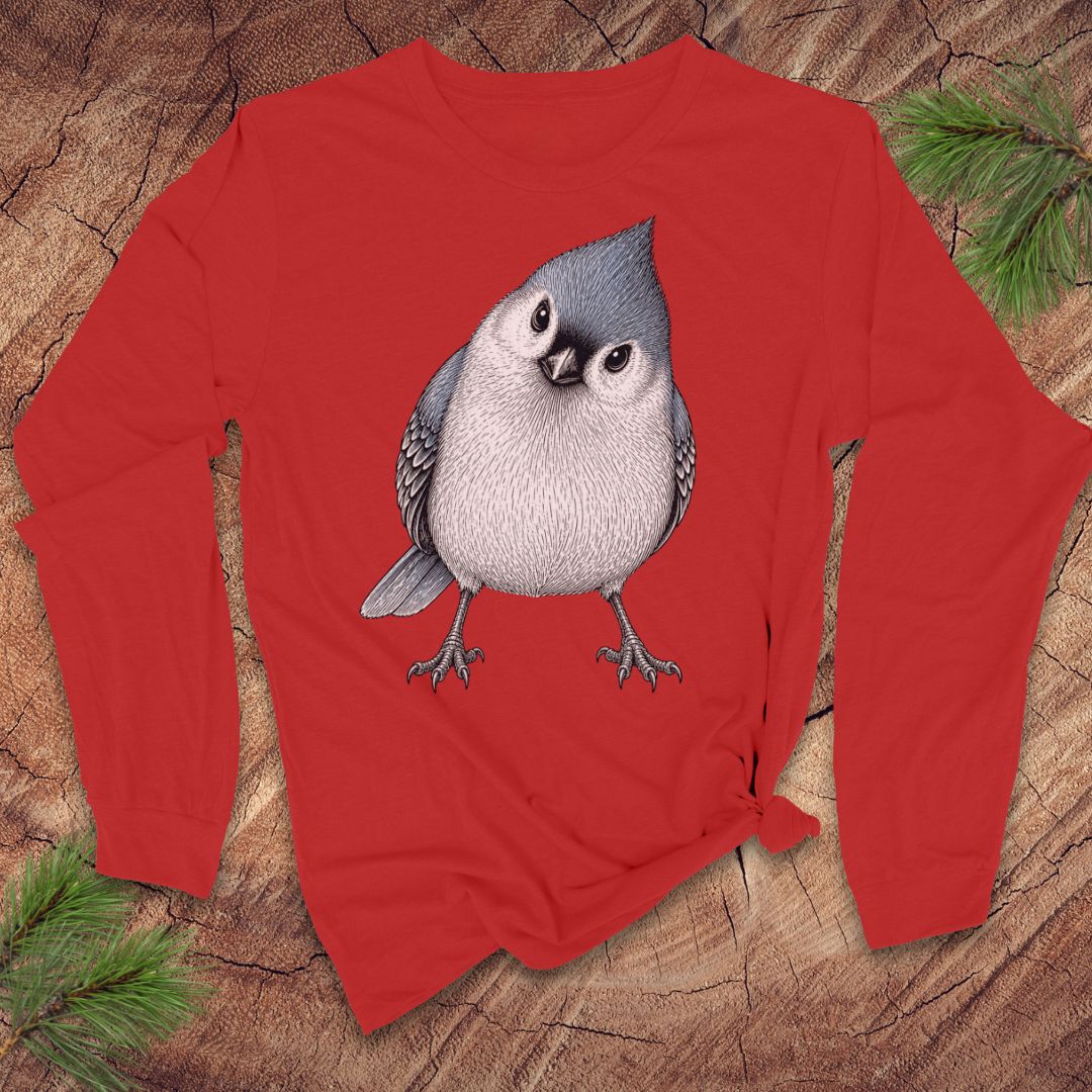 Red long-sleeve t-shirt with a titmouse graphic on a wood background.