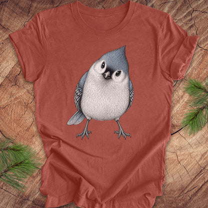 Red t-shirt with a titmouse graphic on a wooden surface