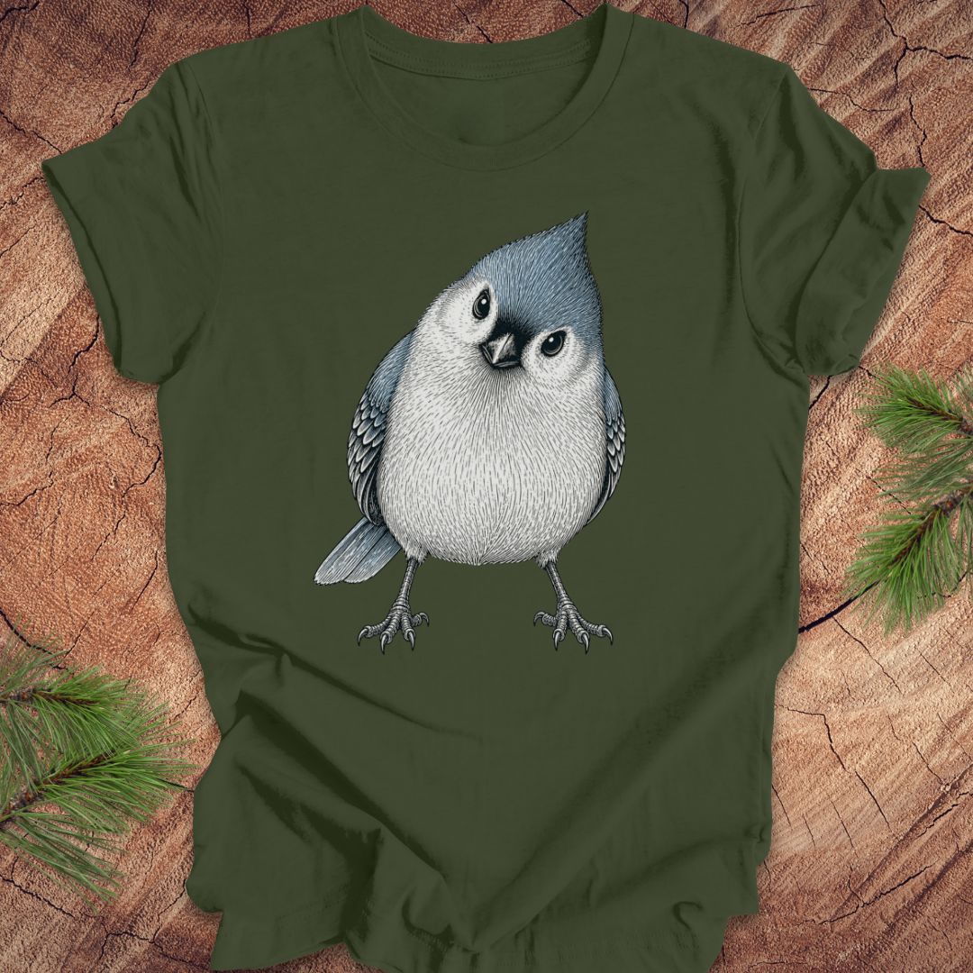 Green t-shirt with a titmouse graphic on a wooden surface
