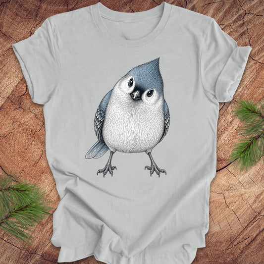 Gray t-shirt with a titmouse design on a wooden surface